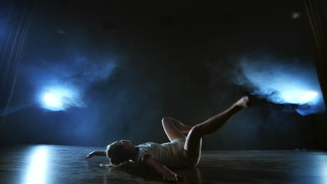 Slow-motion:-Modern-ballet-dancing-woman-barefoot-lying-on-the-floor-doing-spins-and-pirouettes-and-somersaults.